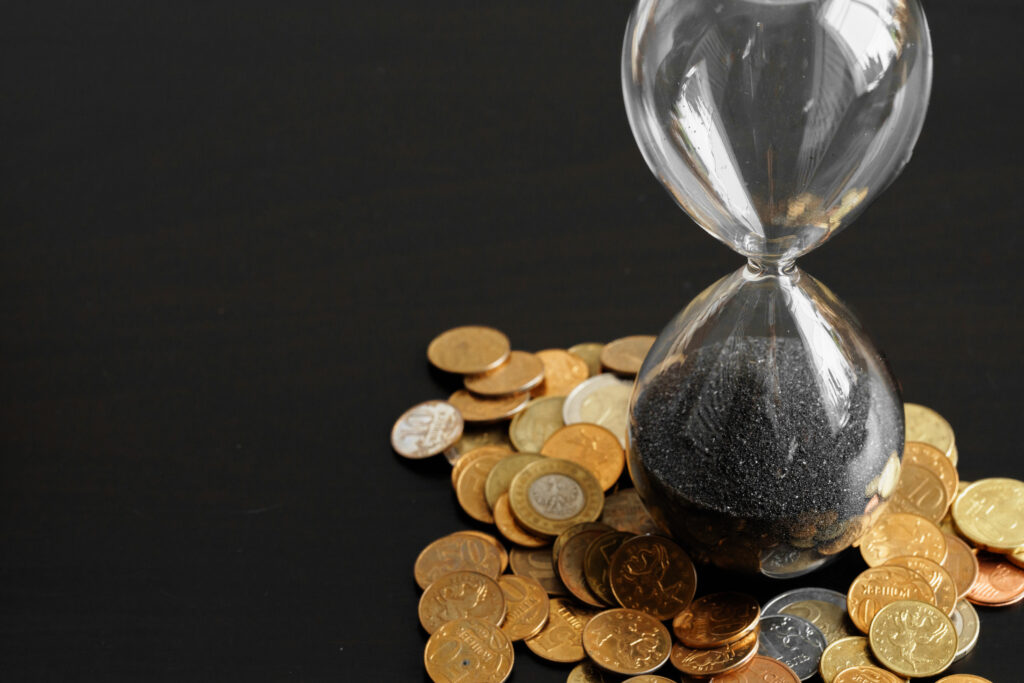 Time Is Money. Close Up Of Hourglass With Money Coins